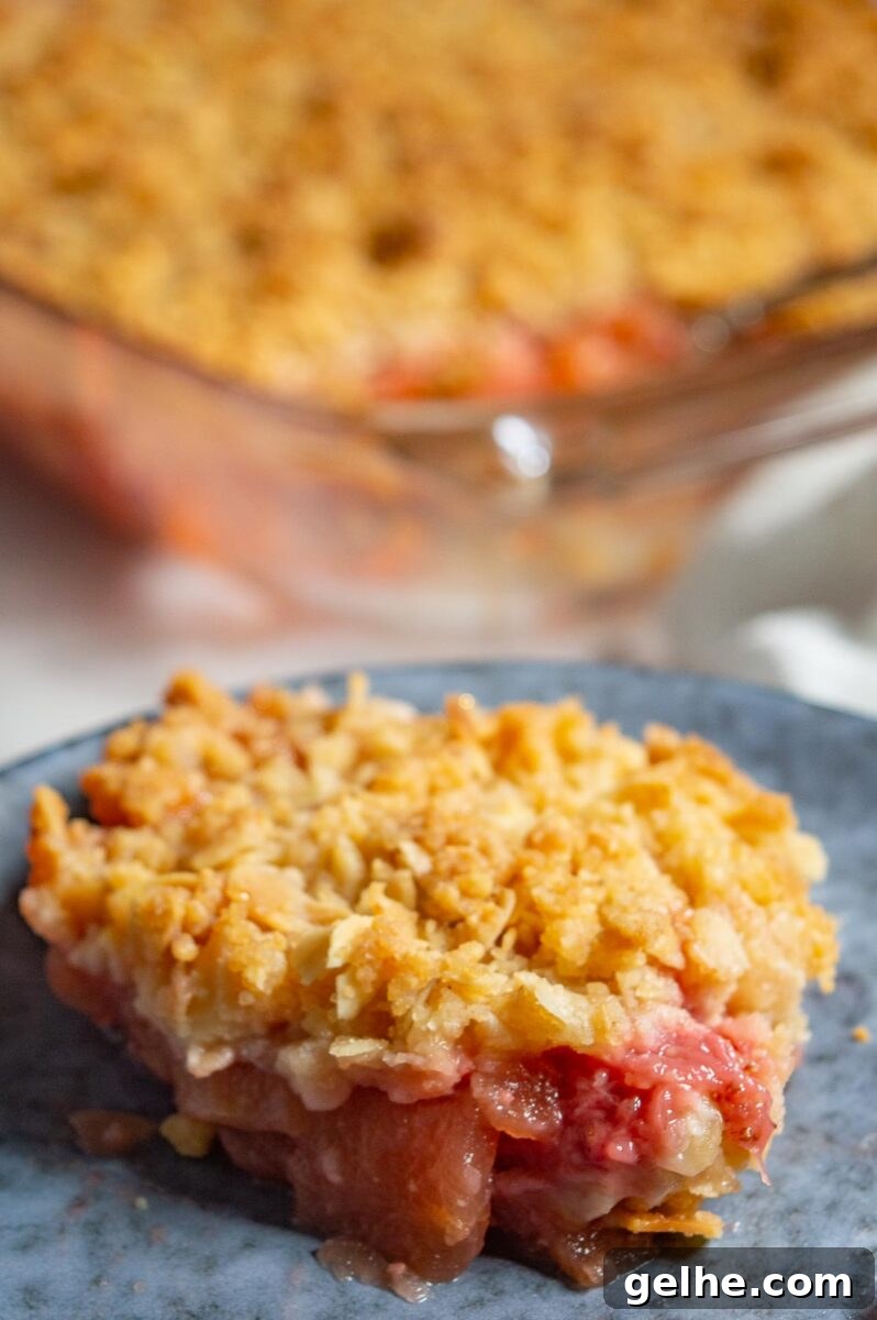Close up of a slice of apple strawberry slices topped with gold crumbles.