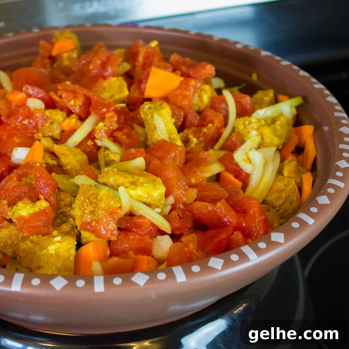 Mediterranean Chicken Tagine with Black Olives and Preserved Lemon 4 Skillet filled with cubed chicken, onion, carrots and tomatoes.