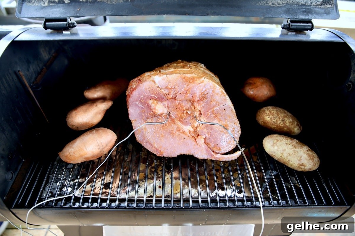 Cooking sweet potatoes on a pellet grill with ham. Spiral ham on a pellet grill with potatoes.