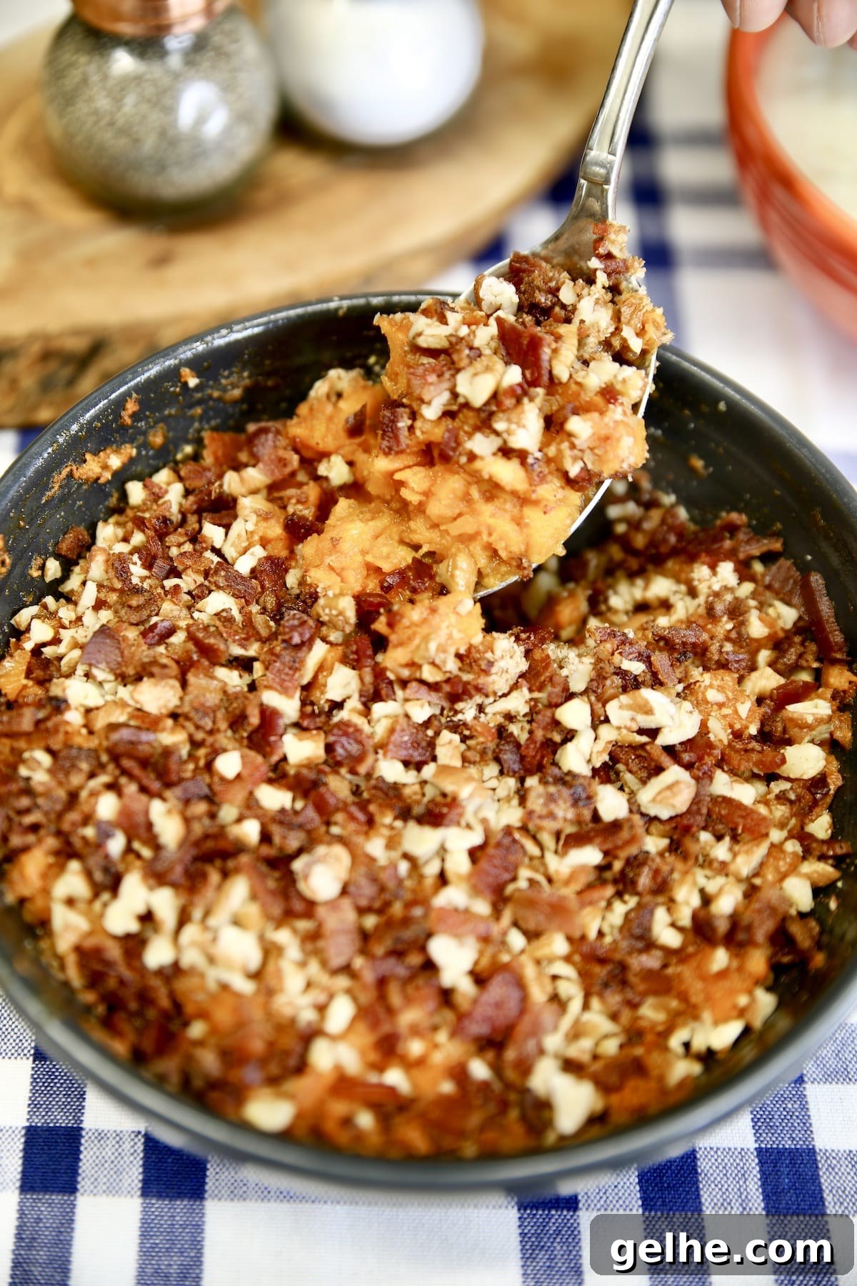 Bacon and pecan sweet potato casserole - easy grilling recipe. Spoon of sweet potato casserole.