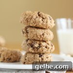 Stack of four chubby cookies on a white plate.