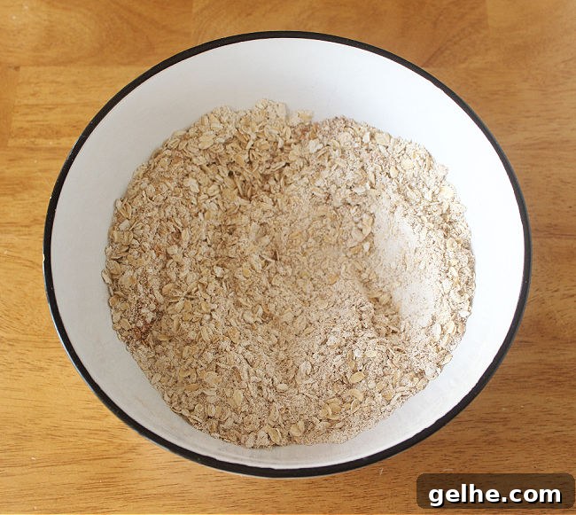 Flour, oats, salt, and baking powder in a large white bowl.