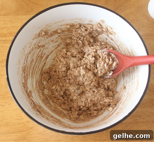 Cookie dough batter being stirred with a red spoon.