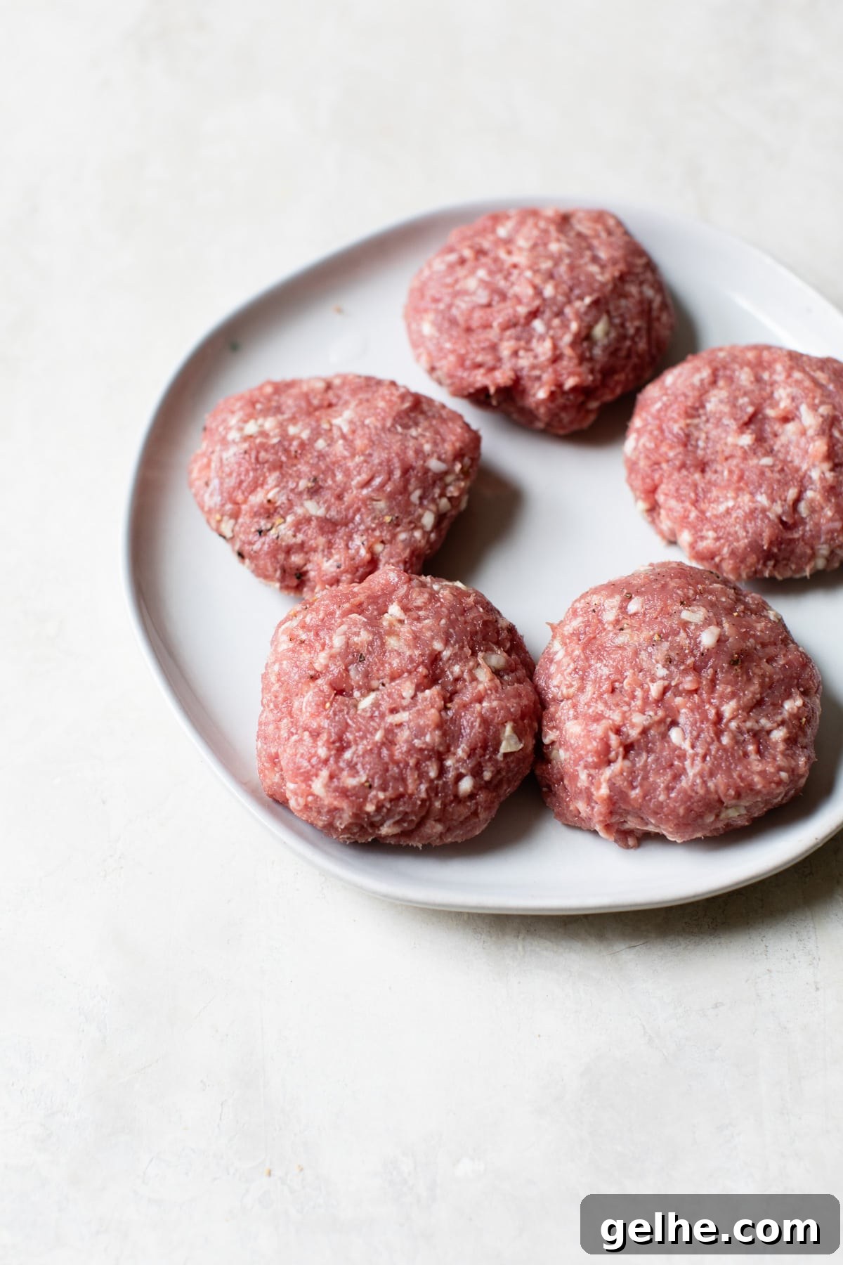 uncooked lamb burgers on a plate