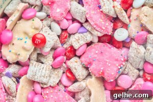 close up view of muddy buddies with animal crackers and red and pink candies.