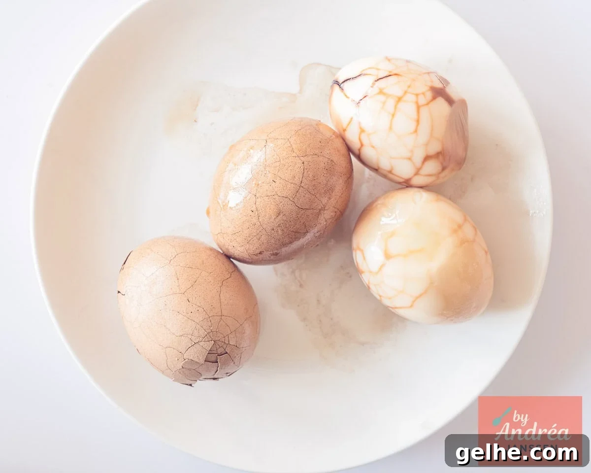How to Make Chinese Tea Eggs: Savory Marble Egg Recipe 7 Chinese tea eggs are being peeled, revealing a marbled pattern