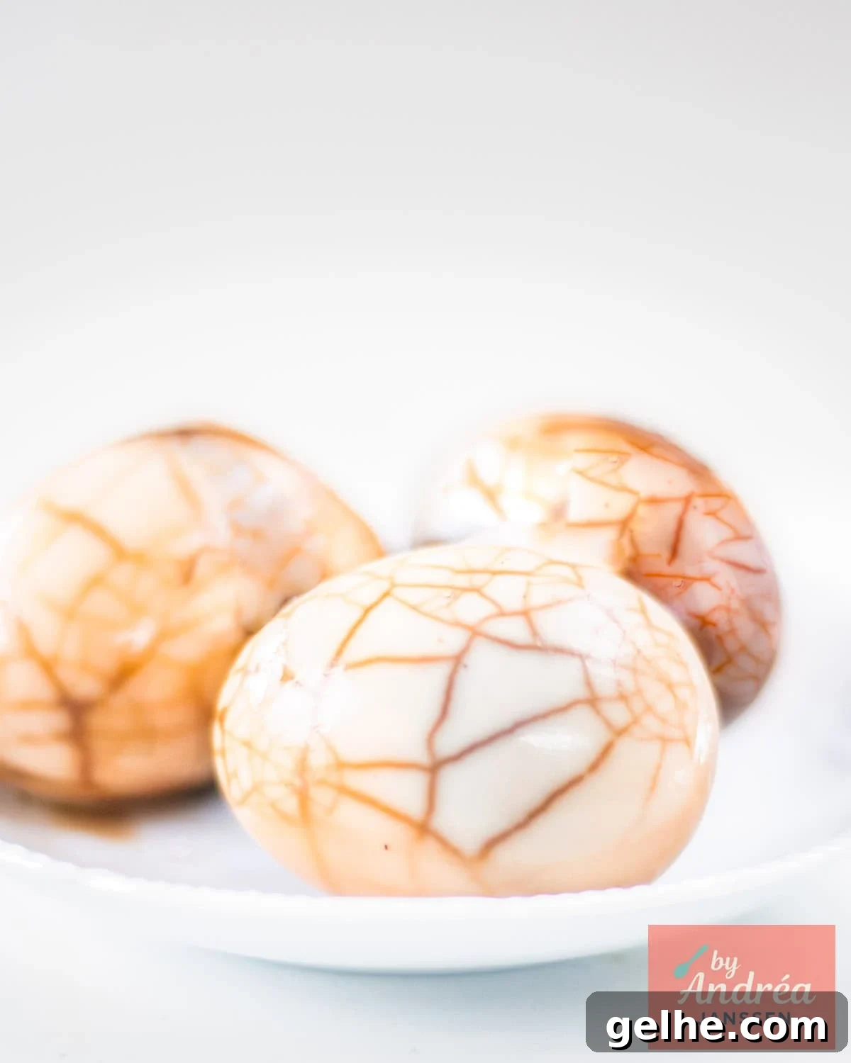 How to Make Chinese Tea Eggs: Savory Marble Egg Recipe 8 Three marbled Chinese tea eggs on a white plate.