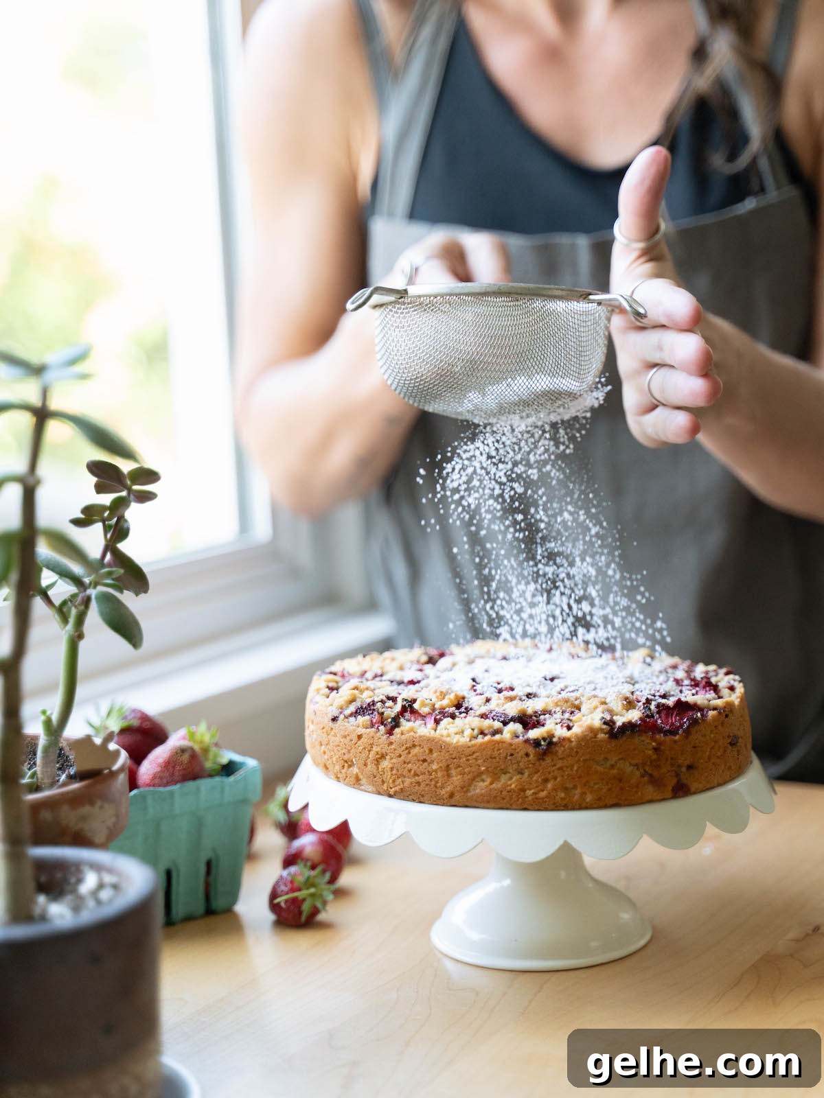 Sifting powdered sugar onto a cake