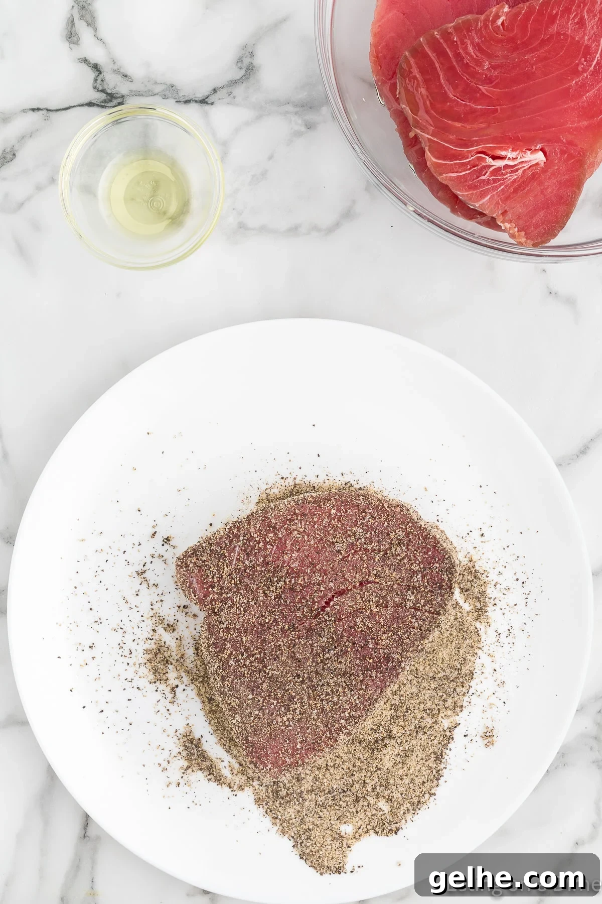 Topping the tuna steaks with seasoning on a plate