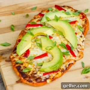square crop of a flatbread pizza on a wooden cutting board.