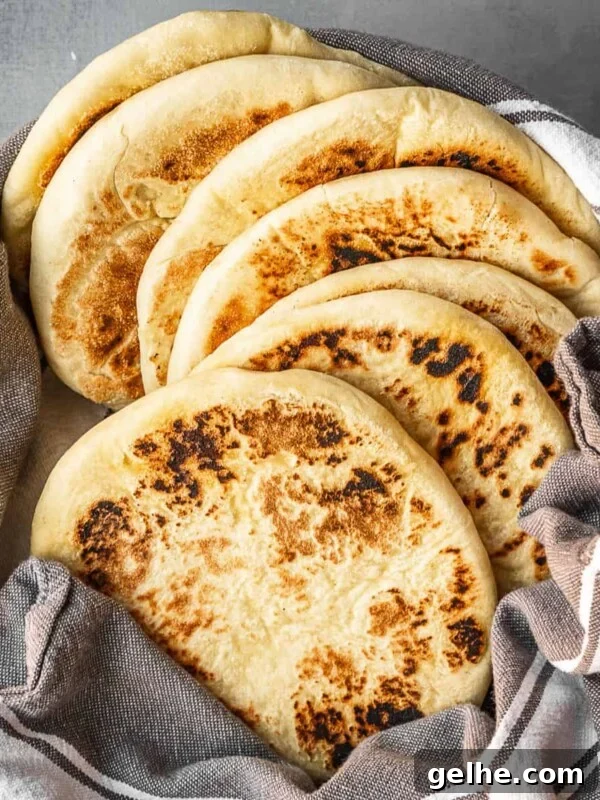 A bowl with a stack of freshly made Greek pitas.