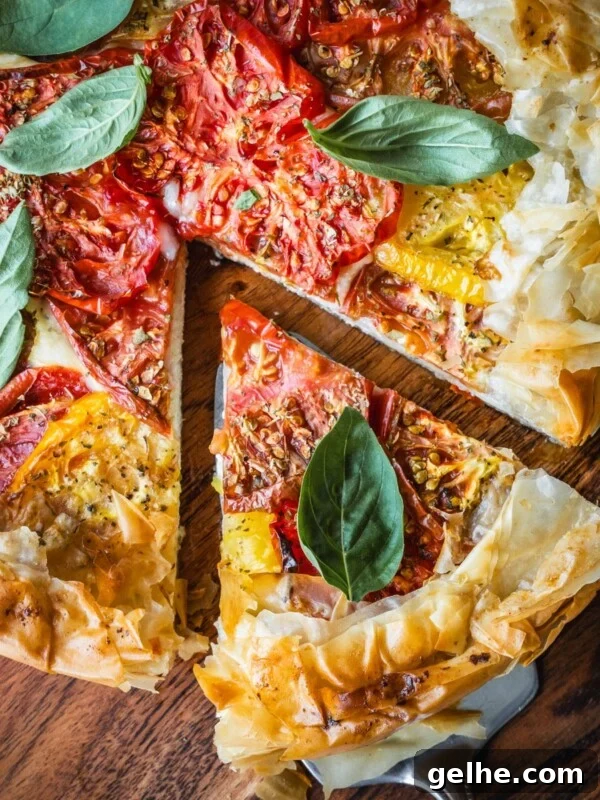 Cheese and tomato pie on a wooden board garnished with basil.