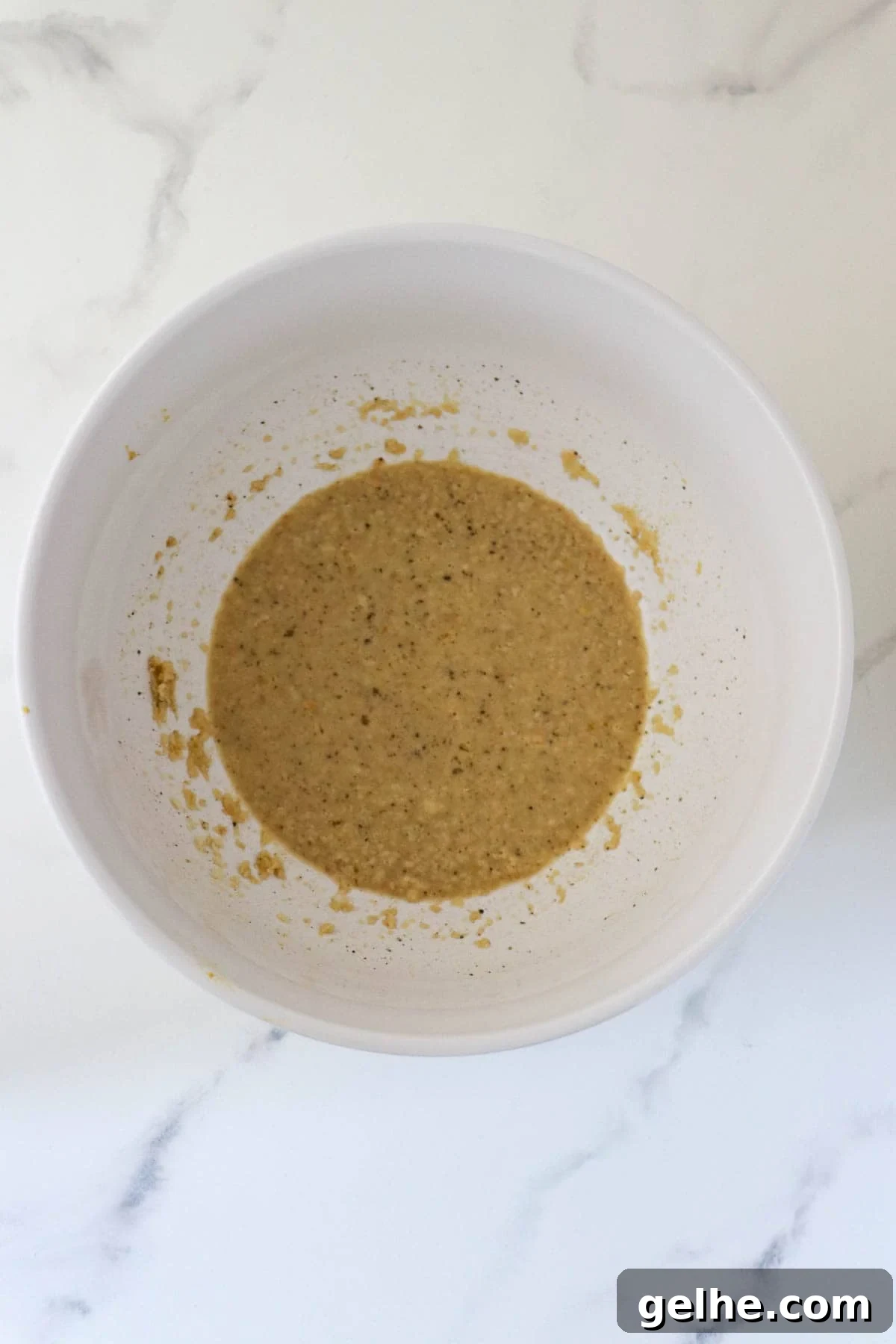 Wet ingredients for Danish Meatloaf whisked together in a white bowl.