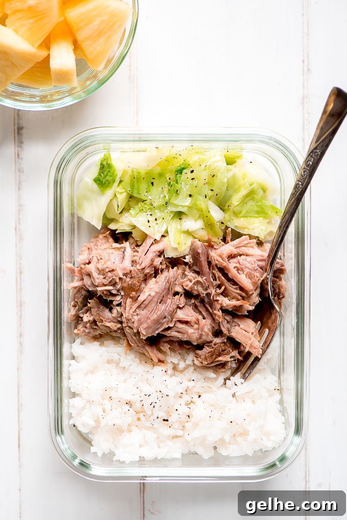 Meal Prep Kaula Pork in a glass containers along with rice, cooked cabbage and a side of pineapple.