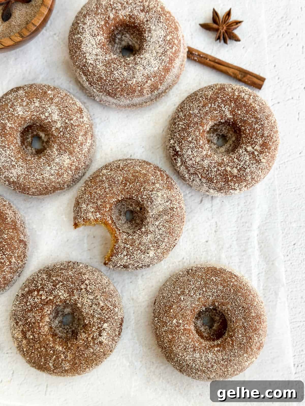 Baked Apple Cider Donuts Recipe | Light Autumn Donut Treat 2 a few baked apple cider donuts with a bite missing from one.