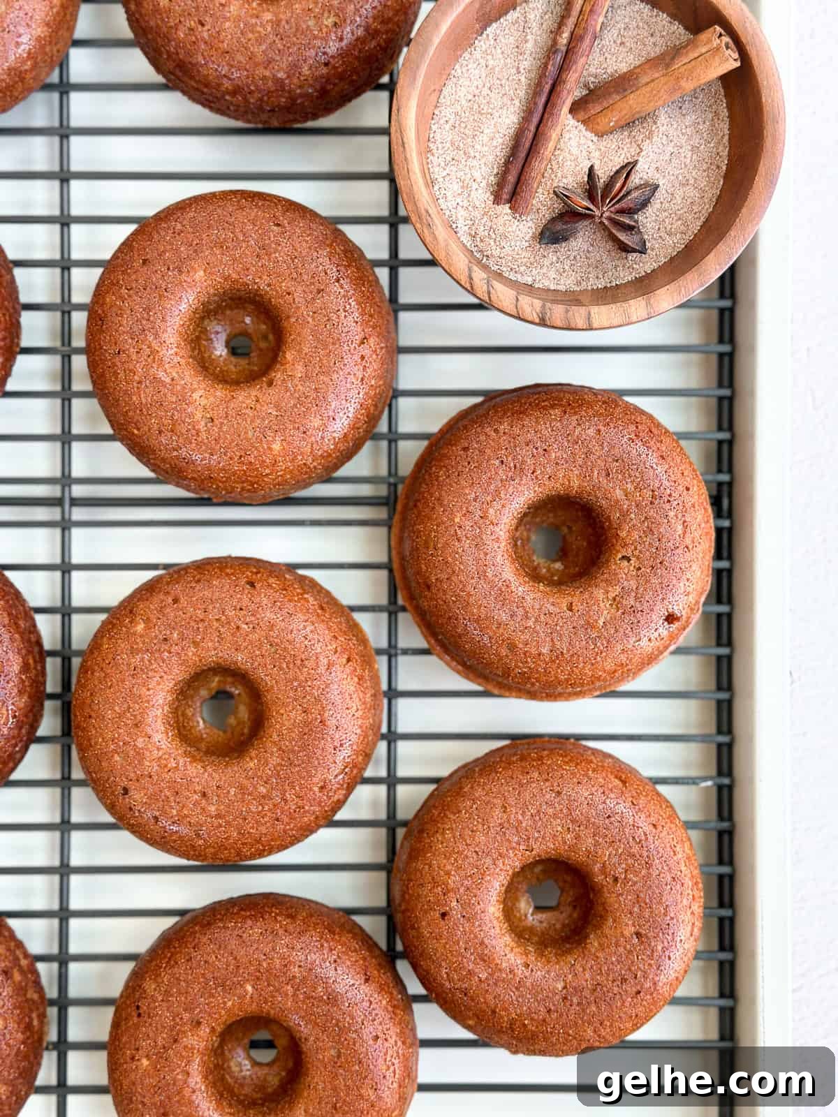 Baked Apple Cider Donuts Recipe | Light Autumn Donut Treat 8 apple cider donuts on a cooling rack after baking.