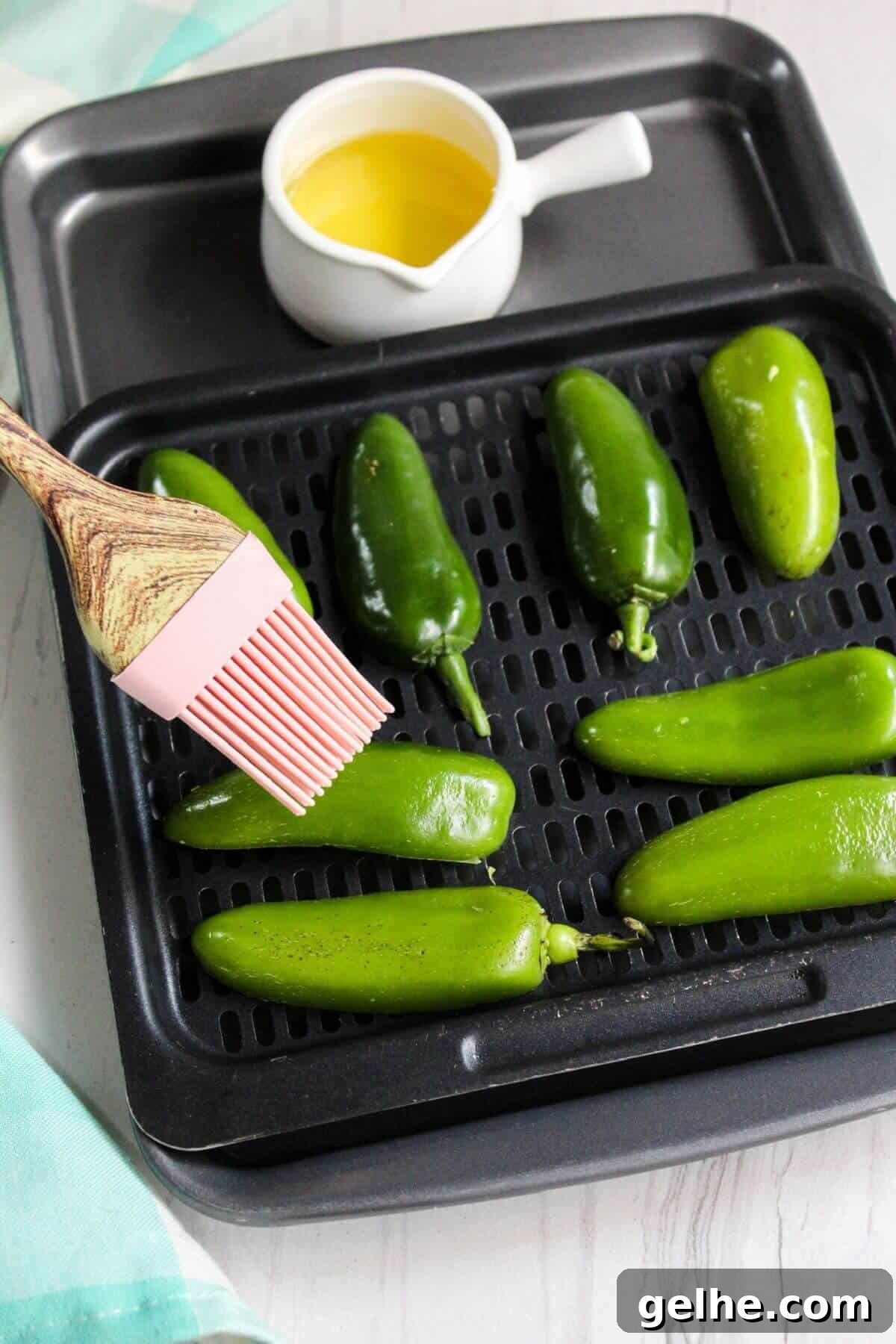 Brushing pepper skins with olive oil.