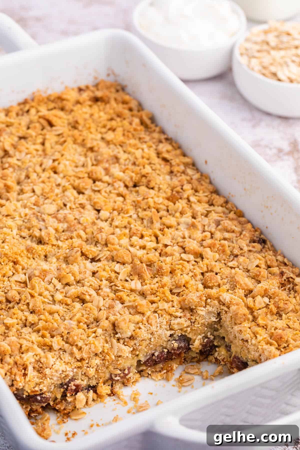 Sour cream raisin bars in a pan with a few squares cut out.