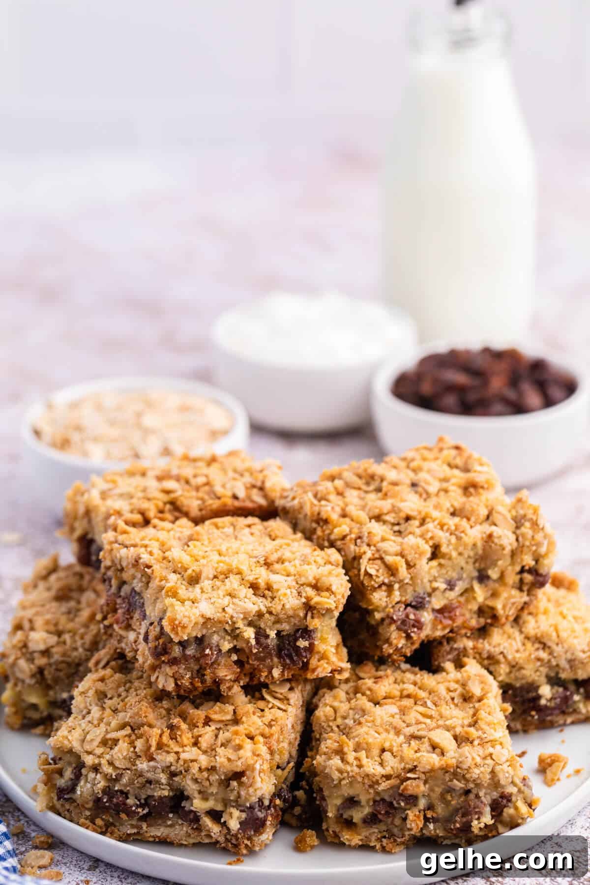 A group of sour cream raisin bars stacked on a plate.
