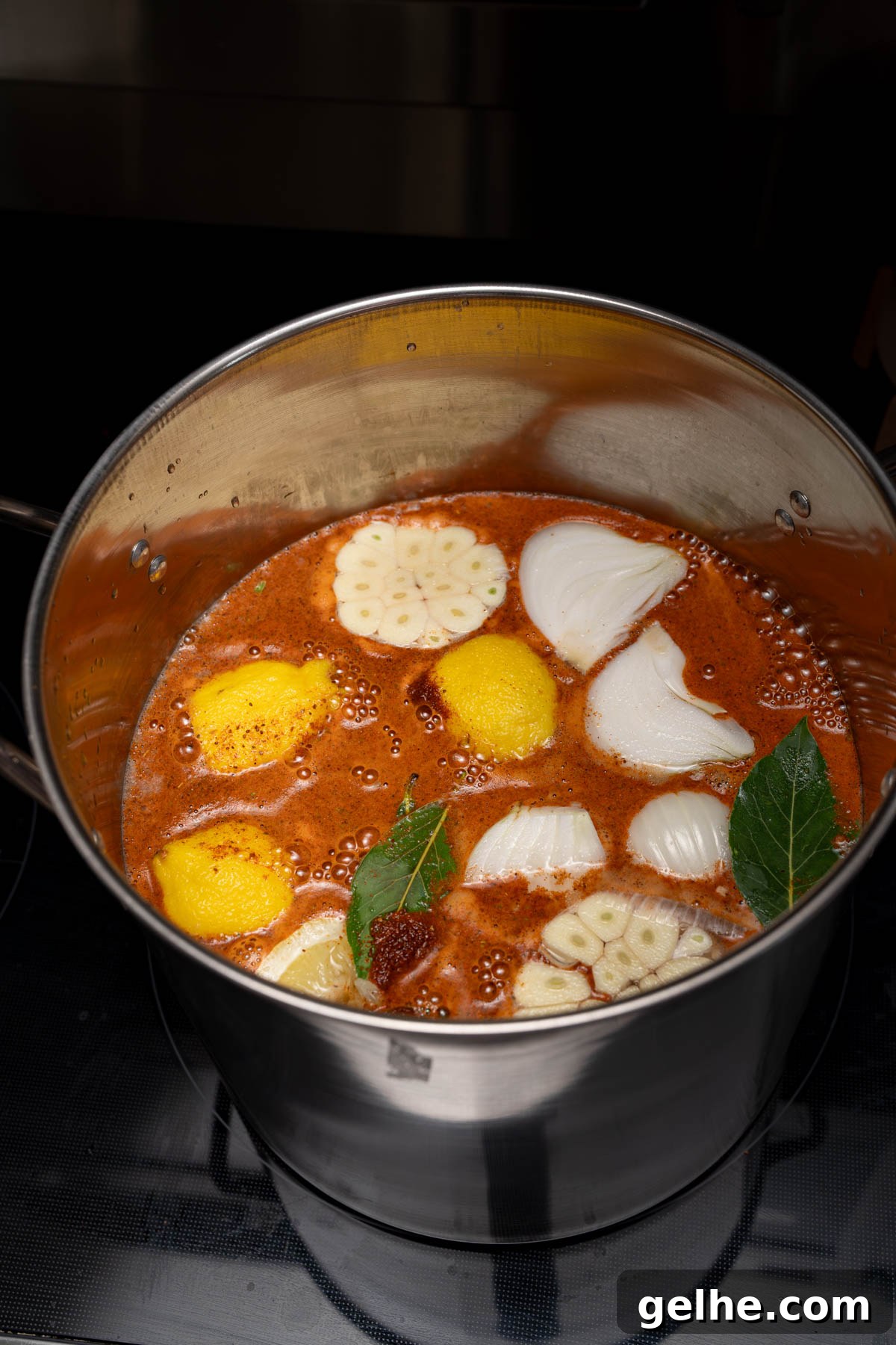 The Old Bay, lemons, garlic, onion, and bay leaves in a large stockpot before boiling.