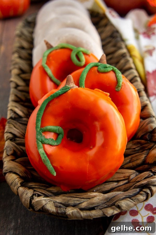 pumpkin donuts decorated with white and orange glazes