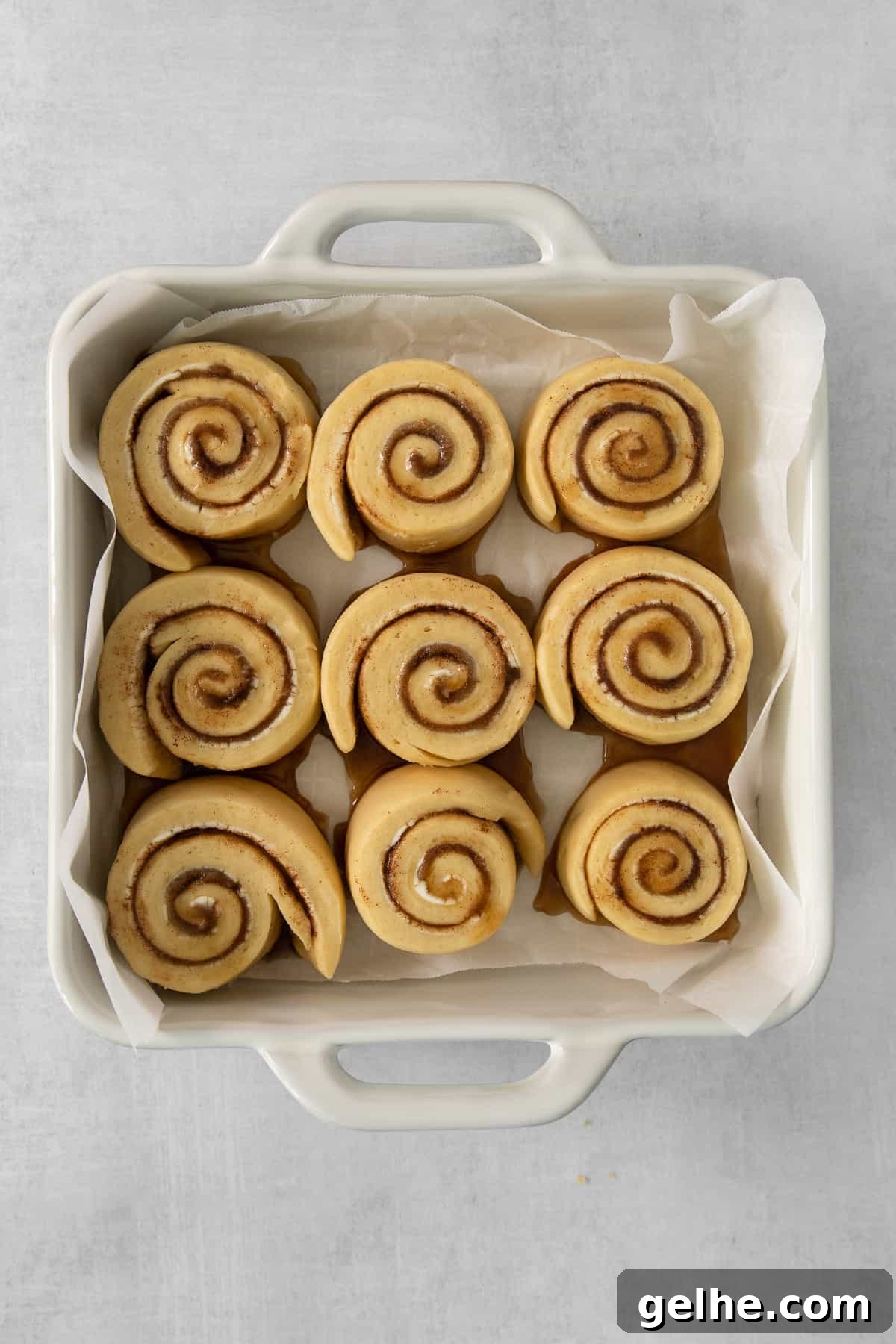 Homemade Cinnamon Rolls Recipe for Soft, Gooey Swirls 4 a white container filled with cinnamon buns on top of a table.
