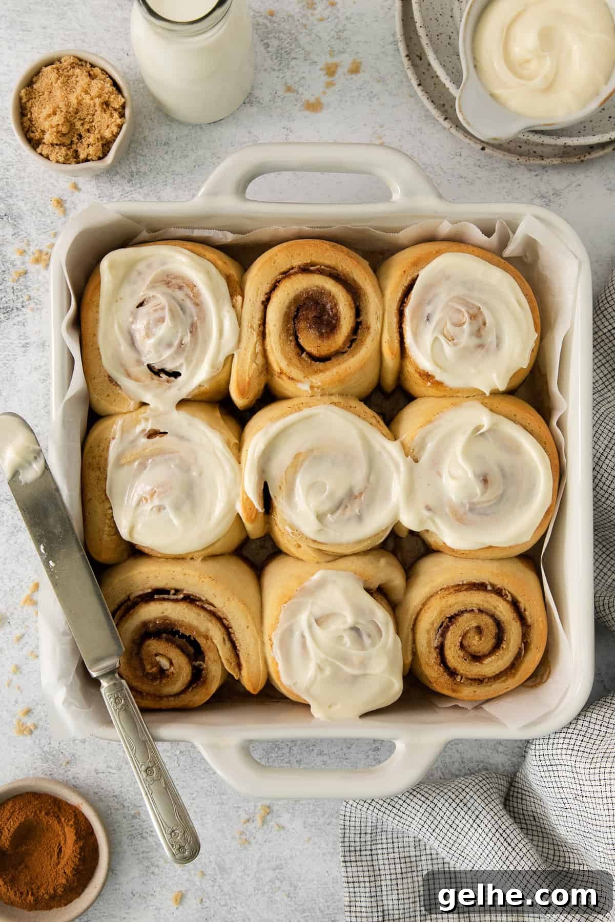 Homemade Cinnamon Rolls Recipe for Soft, Gooey Swirls 5 a pan filled with cinnamon rolls next to a glass of milk.