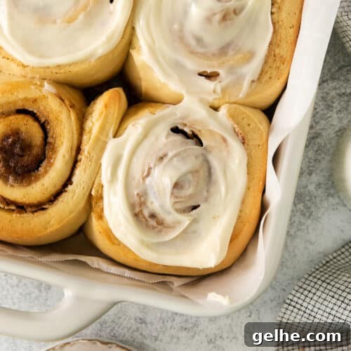 Homemade Cinnamon Rolls Recipe for Soft, Gooey Swirls 6 a tray filled with cinnamon rolls covered in icing.