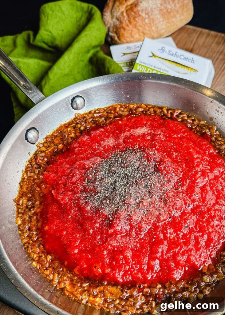 salt and pepper added to fra diavolo sauce in a pan
