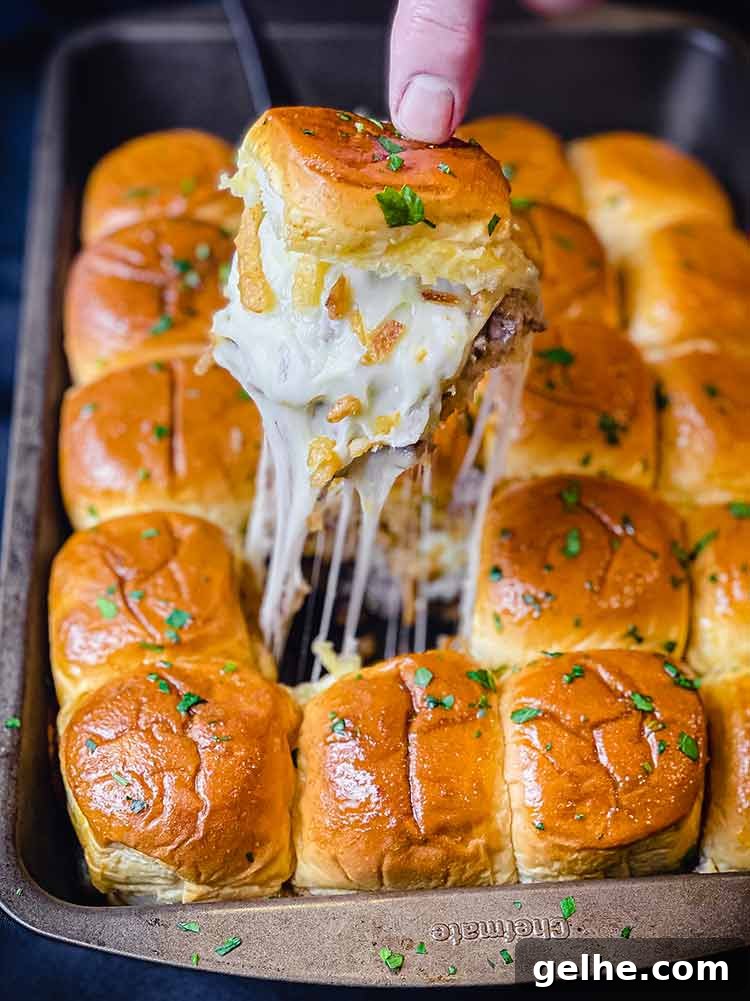 Philly cheesesteak sliders being pulled apart