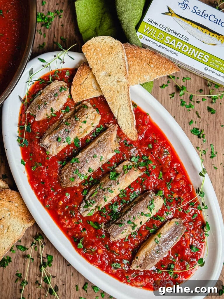 overhead shot of sardines fra diavolo on a platter with herbs