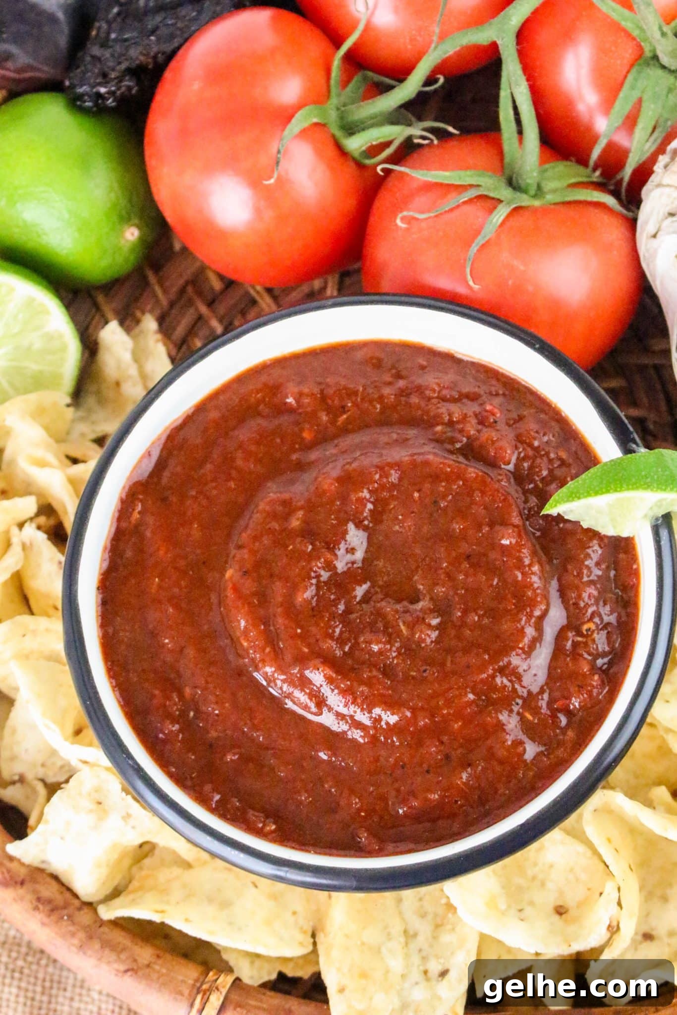 Authentic Red Salsa Roja with Dried Chiles Recipe 10 Top down view of a bowl of smooth dried chile red salsa surrounded with tortilla chips - Hostess At Heart