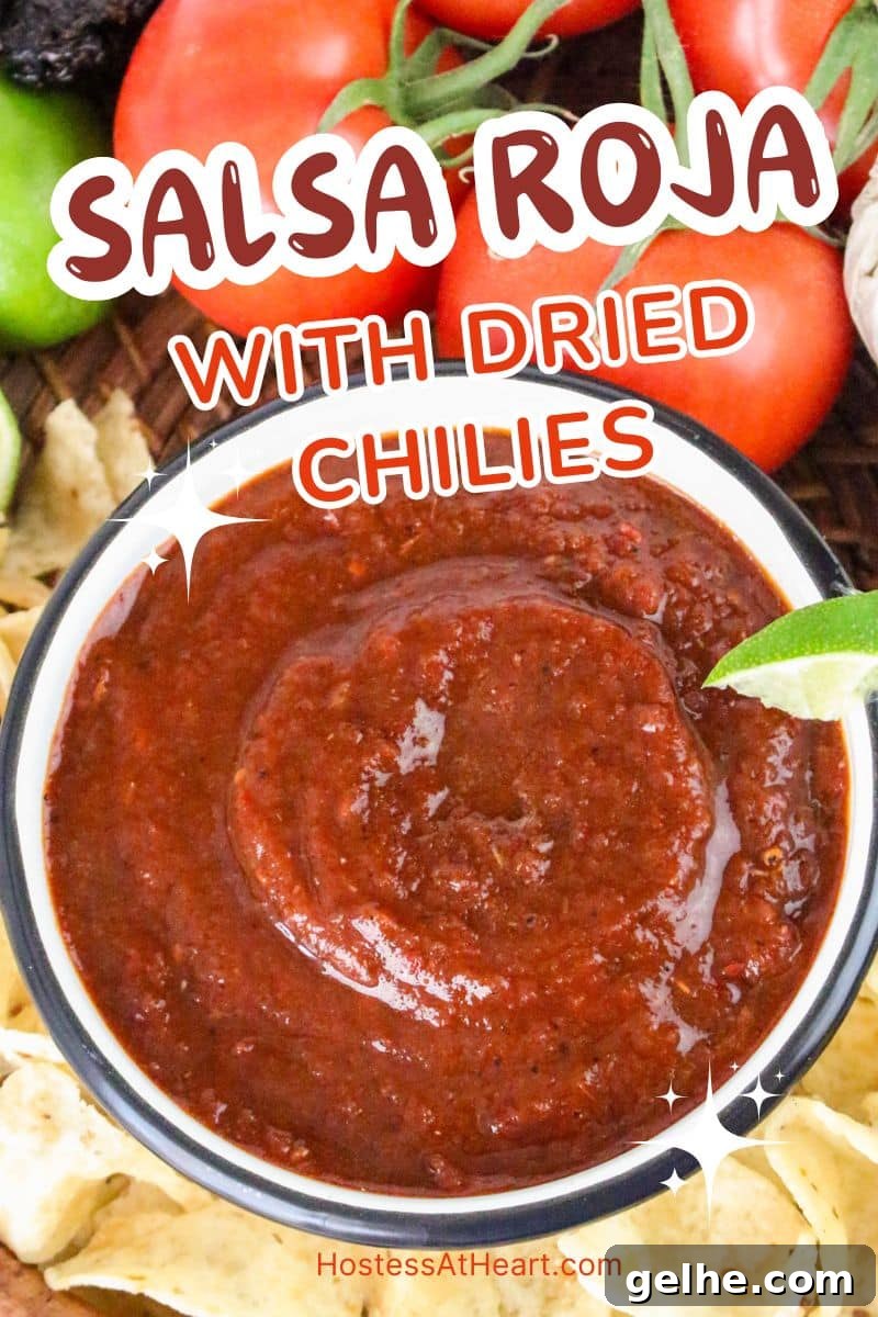 Authentic Red Salsa Roja with Dried Chiles Recipe 12 An image for Pinterest of a bowl of salsa rojo surrounded by tortilla chips - Hostess At Heart