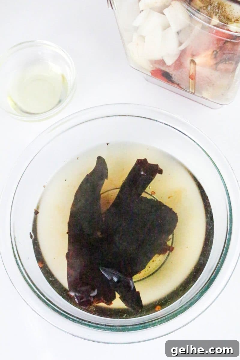 Authentic Red Salsa Roja with Dried Chiles Recipe 6 Roasted dried peppers soaking in a bowl of water. Hostess At Heart