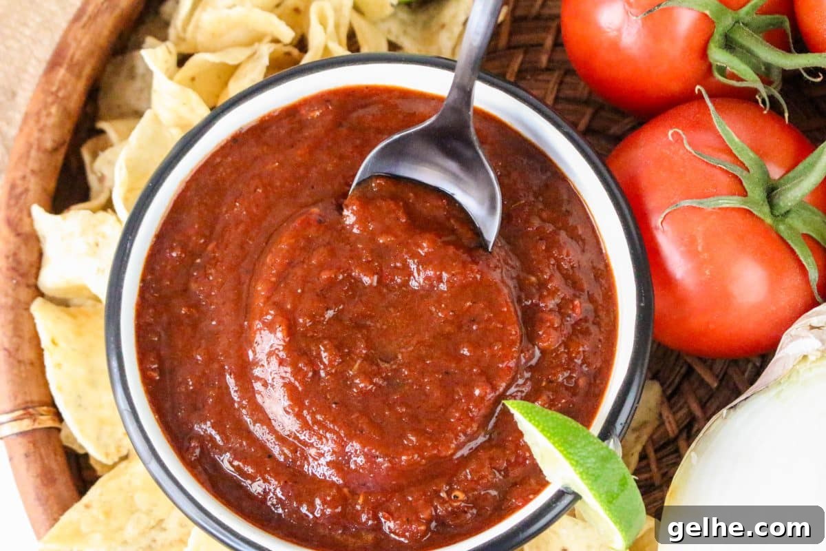 Authentic Red Salsa Roja with Dried Chiles Recipe 8 A bowl of thick dried chile salsa rojo surrounded by tortilla chips for dipping - Hostess At Heart