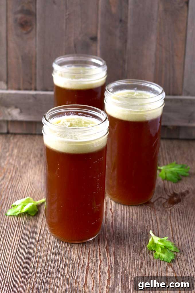 Rich Slow Cooker Beef Bone Broth Recipe for Deep Flavor 3 Three jars filled with slow cooker beef bone broth with a layer of fat on top.