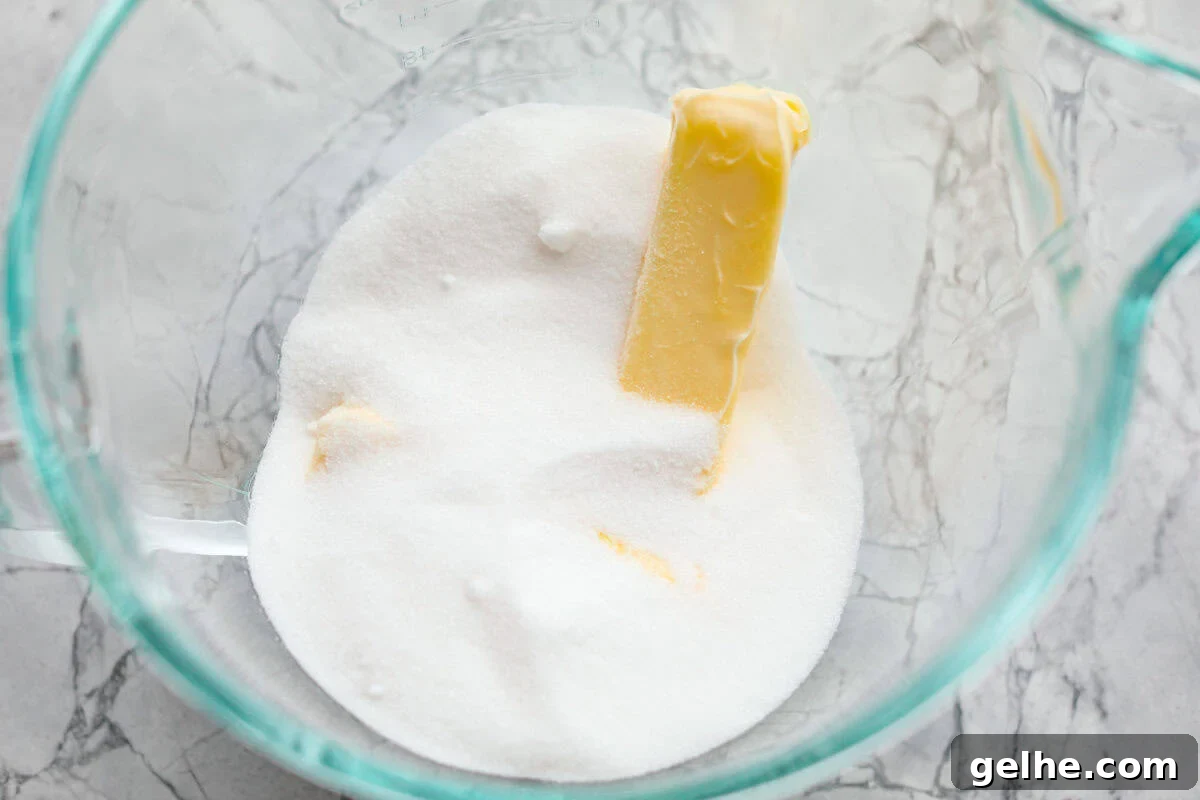 Butter and sugar in a glass bowl.