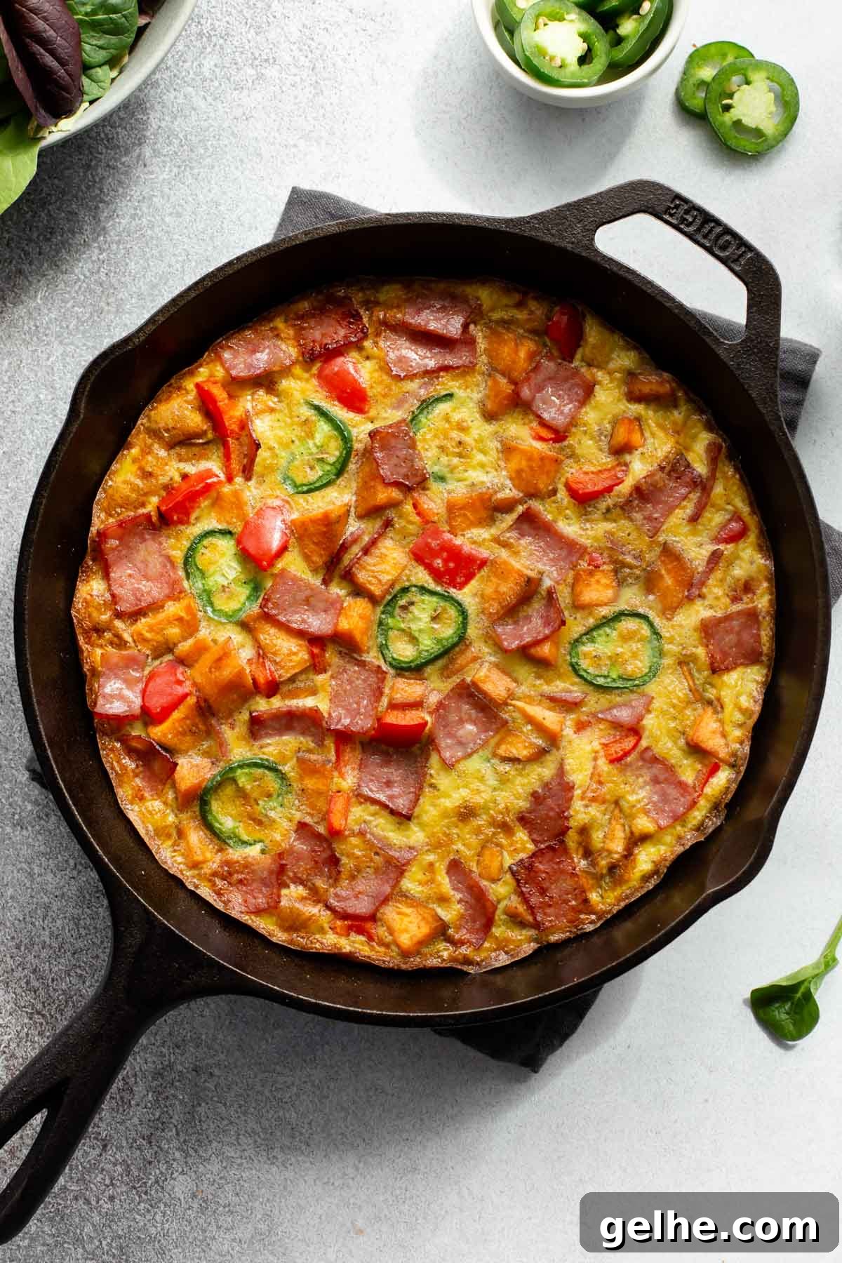 Up close overhead view of a frittata with sweet potato in a cast iron skillet.