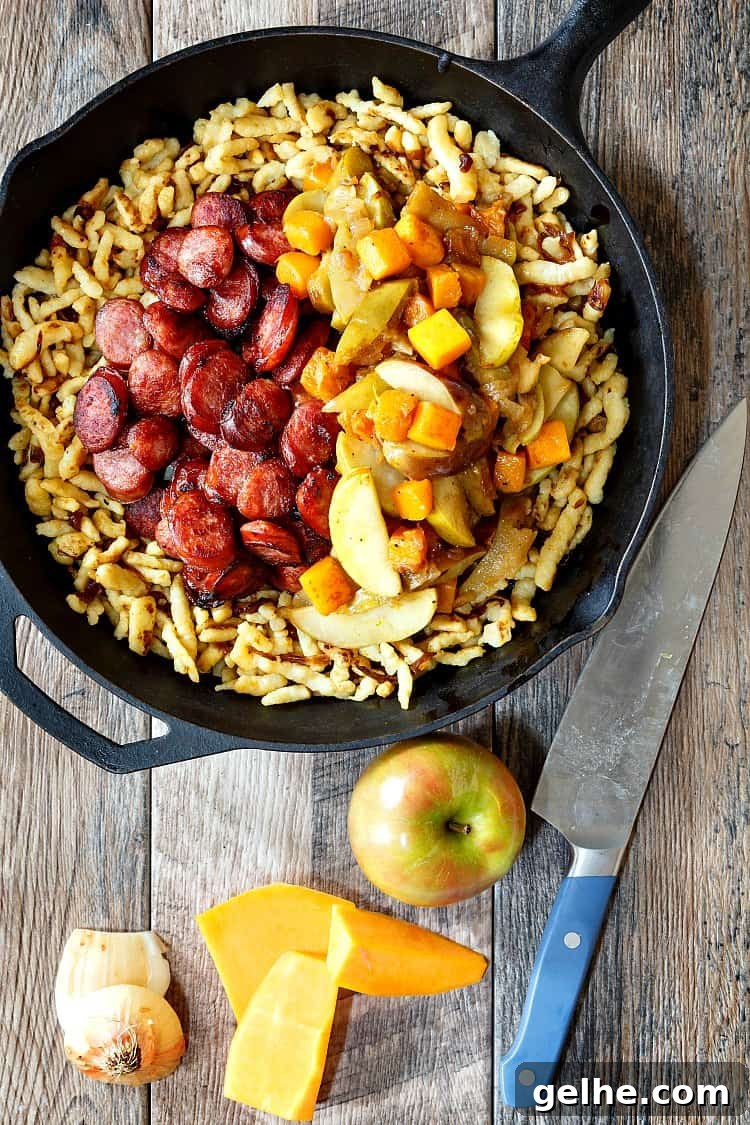 Polish Sausage with Apples, Onions, and Butternut Squash from Pastry Chef Online in a cast iron skillet.