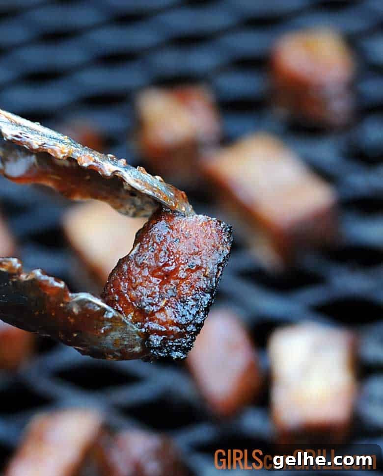 Cranberry Barbecue Turkey Burnt Ends Recipe 2 tongs holding smoked turkey burnt ends.
