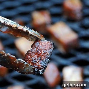 Cranberry Barbecue Turkey Burnt Ends Recipe 12 tongs holding smoked turkey burnt ends