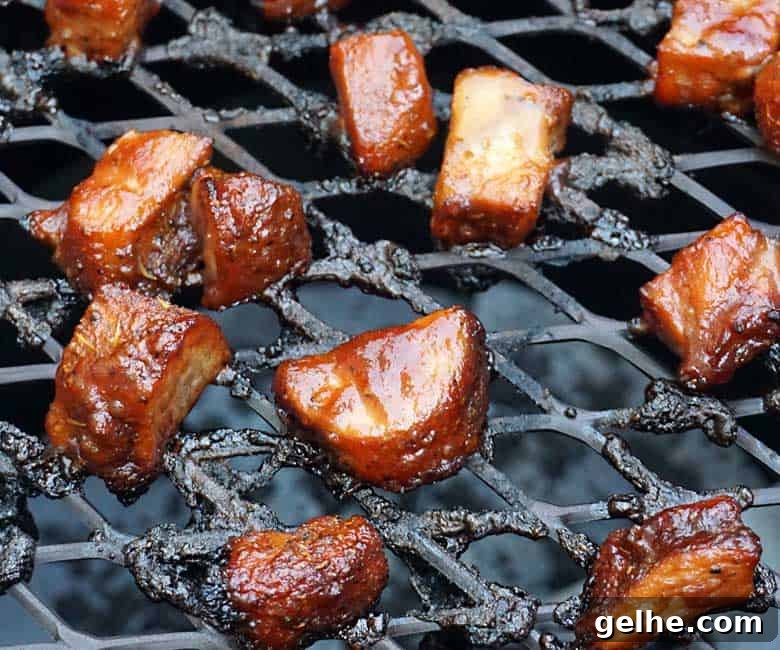 Cranberry Barbecue Turkey Burnt Ends Recipe 7 sauced turkey burnt ends on grill.