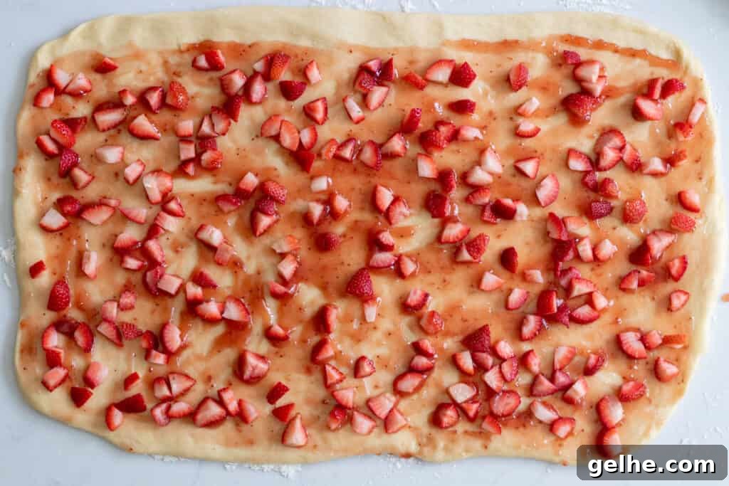 dough spread with strawberry preserves and chopped strawberries