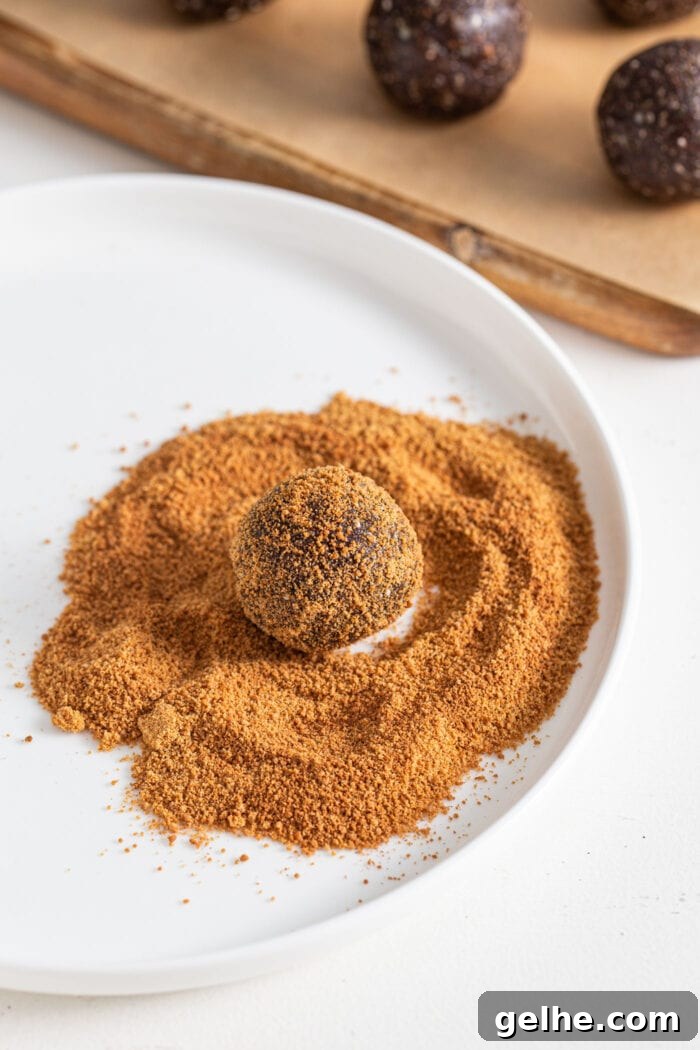 Chocolate energy ball rolled in coconut sugar on a plate.