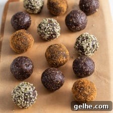 Chocolate energy balls rolled in coconut sugar and hemp seeds on a cutting board lined with parchment paper.