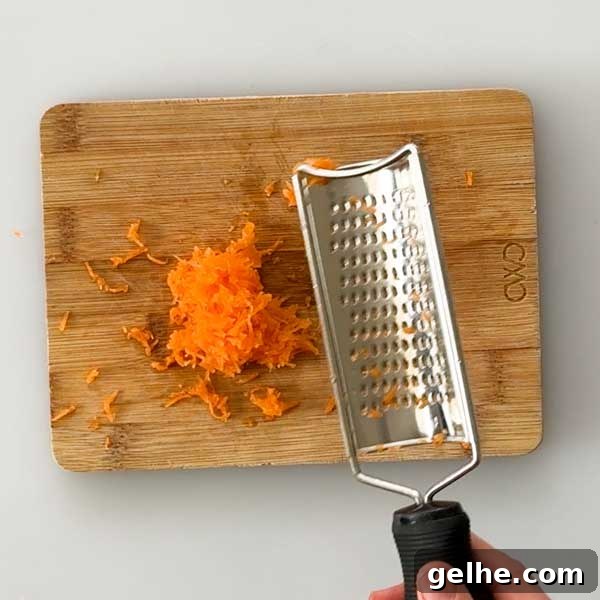 Shredding carrots on a small cutting board.