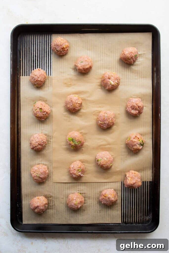 raw gluten-free Asian turkey meatballs in a baking sheet before baking