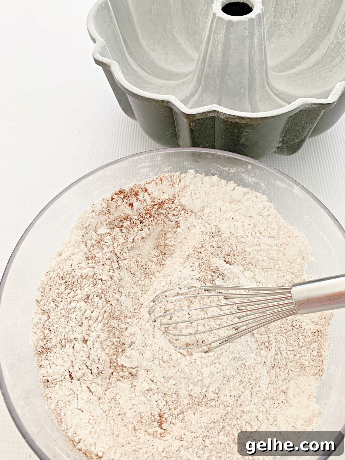 Dry ingredients for Hummingbird Bundt Cake in a bowl with whisk