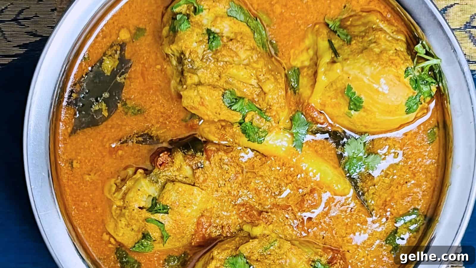 A bowl of Chettinad Chicken Curry garnished with fresh cilantro, displaying chunks of chicken and spices in a rich, creamy sauce.