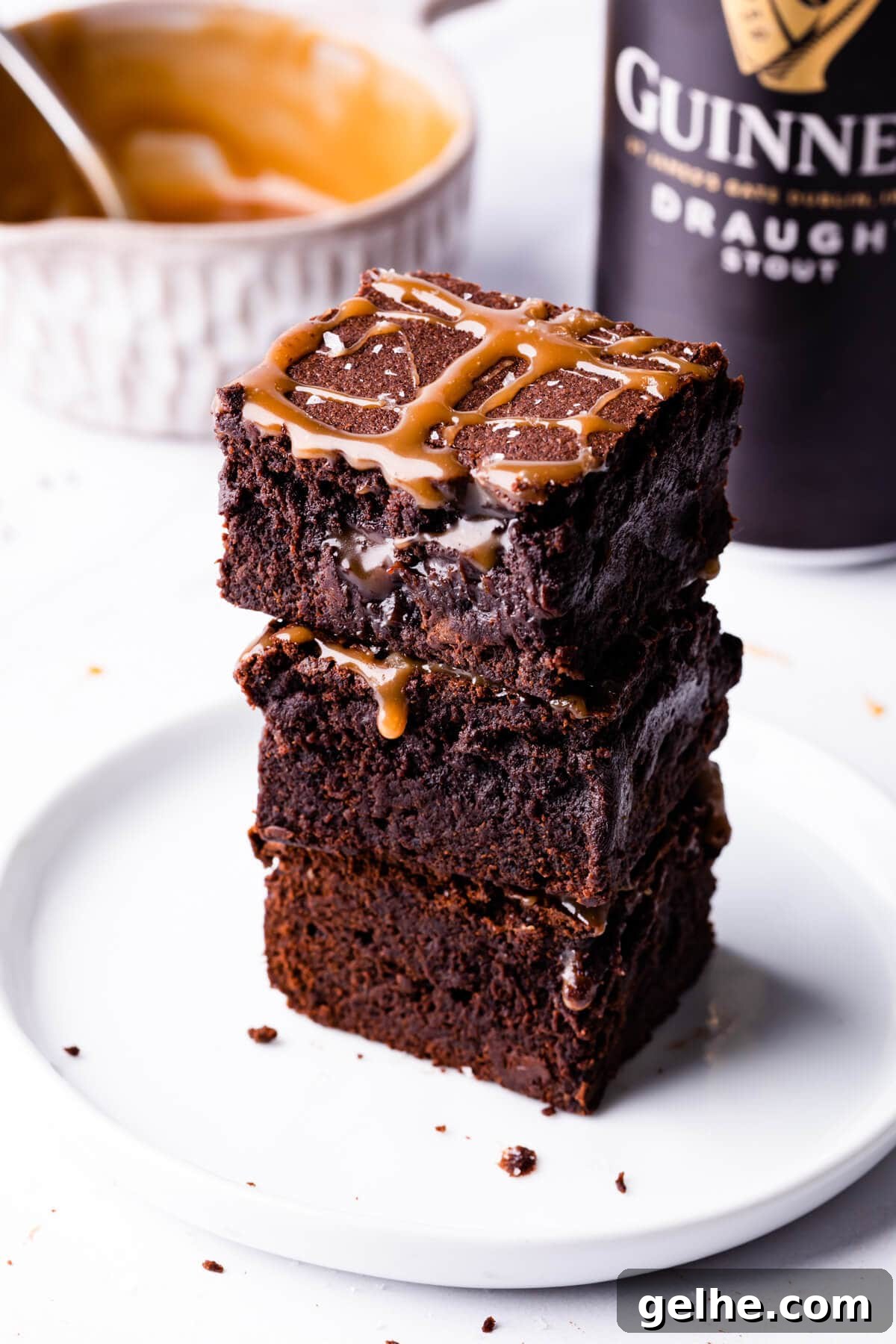 Guinness Chocolate Brownies with Rich Stout Flavor 12 stack of Guinness brownies on a white dessert plate with can of Guinness behind it.
